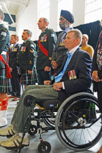 Captain Trevor Greene in wheelchair. This Seaforth officer was struck on the head by an axe in Afghanistan. Standing behind him wearing the turban is The Honourable Harjit Singh Sajjab, OMM, MSM, CD, Minister of National Defence.