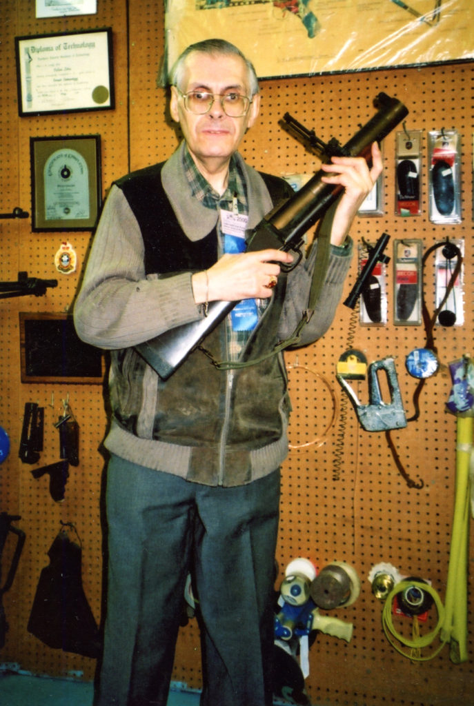 Man standing holding a grenade launcher.