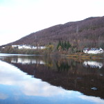 White totel buildings on shore of lake with hills behind. Loch Rannoch, Perthshire, Scotland MacDonald Loch Rannoch Hotel