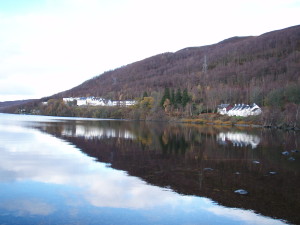 White totel buildings on shore of lake with hills behind. Loch Rannoch, Perthshire, Scotland MacDonald Loch Rannoch Hotel