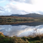 A Scotrtish lake with still water and hills behind. My MacGregors' ancestral home - Kinloch Rannoch in Perthshire, Scotland