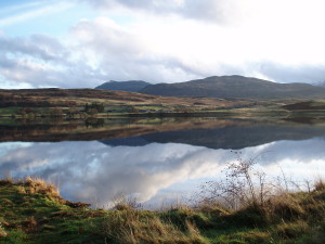 A Scotrtish lake with still water and hills behind. My MacGregors' ancestral home - Kinloch Rannoch in Perthshire, Scotland