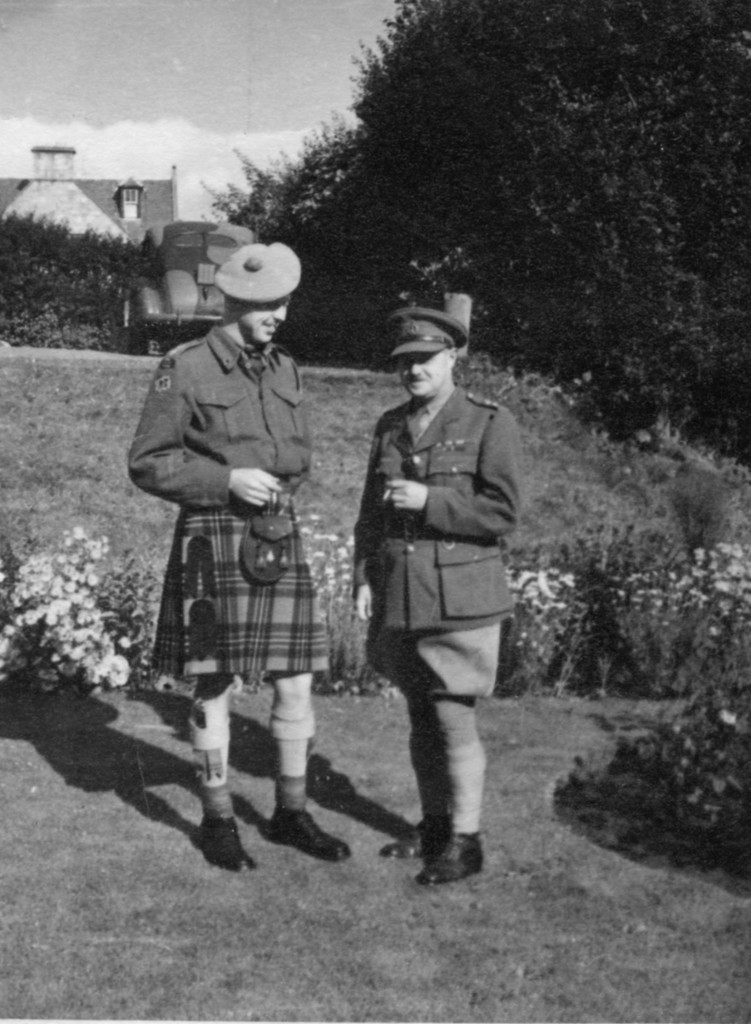 Photo of two Canadian World War II army officers in uniform standing in a scottish garden. 1943 July Lieutenant A. H. Stevens & his uncle Eric at Nairn, Invernesshire