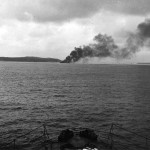 Smoke plume of burning sinking ship.