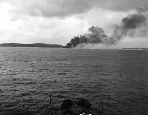 Smoke plume of burning sinking ship.