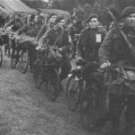 Royal Marine Commandos in Southern England immediately before D-Day, June 1944. They have BSA Airborne Bicycles with the Everest Carrier fitted to the front. They have finished their kit inspection, so the loaded rucksacks, rope, ammunition etc. are now loaded onto the bicycles as they head off to be loaded onto landing craft/ships.