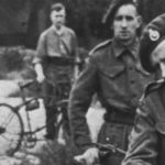 Royal Marine Commandos in Southern England immediately before D-Day, June 1944. They have BSA Airborne Bicycles with the Everest Carrier fitted to the front. They are having a kit inspection, so the loaded rucksack, rope etc. is not loaded onto the bicycles. A bicycle tool pouch, likely off of a rigid Mark IV bicycle, is visible on a bicycle in the background.(DETAIL)