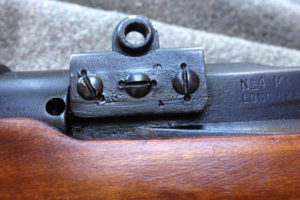 No. 4 MK. I* (T) The front scope pad shows partly obliterated markings which are the Canadian Maltese Cross (meaning non-standard parts) and an upside down "T". The screws are double staked (to prevent screws coming loose) indicating heavy use.