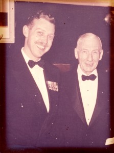 Photo of two men in black tie formal wear. Captain (?) A.H. Stevens with his father W.A.Stevens in the Officers' Mess at Lake Street Armoury in St. Catharines, Ontario. Late 1950s?