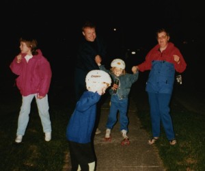 Family group of parents and children with children roller skating. Rob Stevens teaching his daughter Ashley to roller skate. 