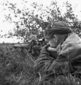 1944-10-09 Cpl. G. E. Mallery, a sniper covering other members of the Scout Platoon Queen's Own Cameron Highlanders of Canada, advancing towards Fort de Brasschaat, Belgium (L&AC MIKAN 3409540)