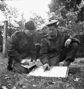 1944-10-09 Lieutenant W. C. Pearson on right briefing sniper Sgt. P. A. Rylaasden of the Scout Platoon, Queen's Own Cameron Highlanders of Canada at Fort de Brasschaet (L&AC MIKAN 3409536)