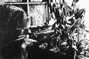 1944 British sniper Private Sutcliffe in Caen, France. Second view of him at the window.