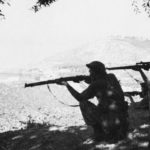 Two soldiers in silhouette firing rifles. British Commandos in Albania during WWII. Man on right has a No. 4 MK. I (T) They are likely with No 2 Commando. (Colin M. Stevens' Collection)