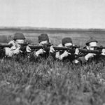 Five Canadioan snipers pose in prone shooting position.