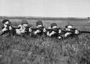 Five Canadioan snipers pose in prone shooting position.