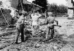 Two British soldiers march a German prisoner away.