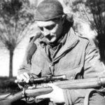 Sergeant H. A. Marshall cleaning his No. 4 MK. I (T) sniper rifle's No. 32 scope.