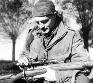 Sergeant H. A. Marshall cleaning his No. 4 MK. I (T) sniper rifle's No. 32 scope.