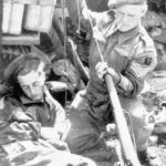 Sniper believed to be of the 5th Battalion, The East Yorkshire Regiment of the 50th (Northumbrian) Division cleaning his No. 4 MK. I (T) rifle using a German pull-through while another man sleeps. This Battalion was [part of the 69th Infantry Brigade which was pulled back to the UK in December 1944 so this photo is likely between June 6 1944 and December 1944. (Royal Armouries Library)