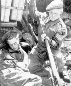 Sniper believed to be of the 5th Battalion, The East Yorkshire Regiment of the 50th (Northumbrian) Division cleaning his No. 4 MK. I (T) rifle using a German pull-through while another man sleeps. This Battalion was [part of the 69th Infantry Brigade which was pulled back to the UK in December 1944 so this photo is likely between June 6 1944 and December 1944. (Royal Armouries Library)