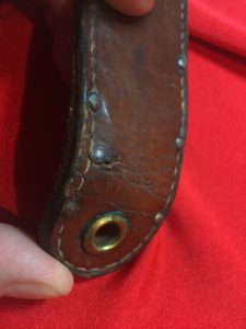 USMC Stiletto scabbard - front view of lower end showing the large grommet. This 4th version of scabbard does not have the metal plates. Note the minor damage to this scabbard from being worn. The Marine sat down and the leather tip bent. Colin M Stevens' Collection
