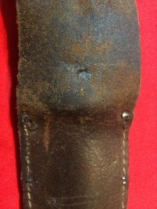 USMC Stiletto scabbard - back view of centre. The two holes of prongs of a rivet for a low retaining strap are also visible. - Colin M Stevens' Collection