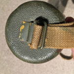 Bottom end of carrying case showing the buckle for attaching the carrying strap.