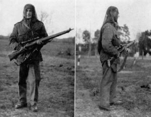 WWII British sniper wearing camouflaged Denison smock. faceveil on head and carrying No. 4 (T) sniper rifle with No. 32 scope. Smock was designed for airborne troops and has a crotch strap which keeps smock from riding up WBSTTR - Shore 1948 fp 103