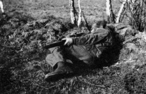 WWII British sniper demonstrating an unconventional shooting position, one often used in British match rifle competitions. It is a good position to drop into for a quick shot from sloping ground or to fit into a small shell hole or hide. WBSTTR - Shore 1948 fp 135 bottom