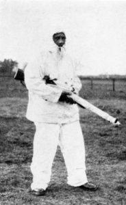 British sniper wearing a white snow suit and carrying his sniper rifle.