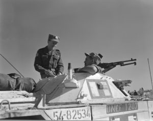 Rwo men inside white painted Ferret Scout Car.