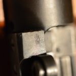 The special Enfield Examiner's mark on the top of the front scope pad. This mark in this location is unique to the 1,403 rifles converted by RSAF Enfield.