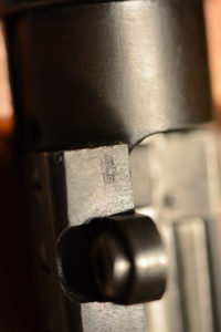 The special Enfield Examiner's mark on the top of the front scope pad. This mark in this location is unique to the 1,403 rifles converted by RSAF Enfield.