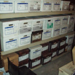 Artifact storage iising Banker Boxes n the Fan Room. "Like with like" i.e. webbing together, shoes together etc.