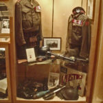 Case 7 upper - Victoria Cross Winners - LtCol Cec Metritt VC on left (one of his part-WWII BD blouses) and on right replica of Smokey Smith VC BD blouse. Decorations and medals are replicas or generic.