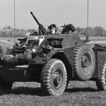 Ferret Scout Car with a helicopter hovering overhead.