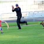Police dog handler with puppy police dog and young boy with a drag for the puppy to grab. with his teeth. (D7100a 014)