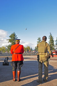 "Here comes your ride Sir!" Two RCMP members awaiting the arrival of the RCMP helicopter.