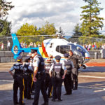 "Hey Sergeant! The Pilot says I am too big to go up in the helicopter!" RCMP members (regular and Auxilliary) talking with the helicopter pilot.