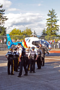 "Hey Sergeant! The Pilot says I am too big to go up in the helicopter!" RCMP members (regular and Auxilliary) talking with the helicopter pilot.