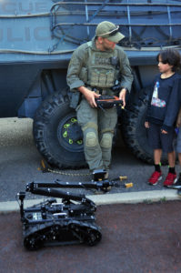 "Hey kid, can you show me how to work this thing?" Emergency Response Team member with remote controlled robot and a visitor.