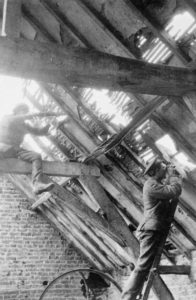 Sniper in rafter of a barn and observer lower down.