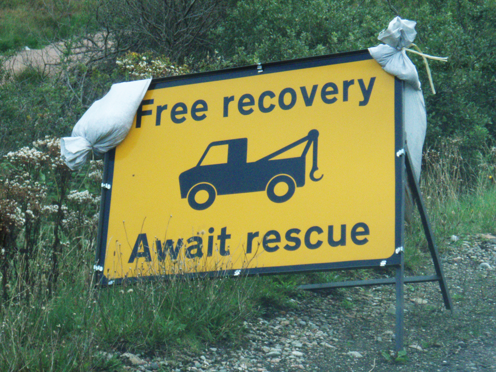 Highway sign FREE RECOVERY AWAIT RESCUE, Glencoe, Scotland. 