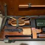 L42A1 - Left section in transit chest. Showing 1955 dated No. 8 MK. I scope case (mismatched) , Scout Regiment Telescope in its case, rare original "J" bracket to mount IWS, rifle and sling, chamber cleaning stick.