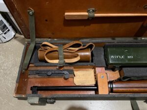 L42A1 - Left section in transit chest. Showing 1955 dated No. 8 MK. I scope case (mismatched) , Scout Regiment Telescope in its case, rare original "J" bracket to mount IWS, rifle and sling, chamber cleaning stick.