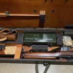 L42A1 - Centre section in transit chest. Showing 1955 dated No. 8 MK. I scope case (mismatched) NOS scope case strap in packaging, cleaning kit stowed, rifle and sling, chamber cleaning stick.