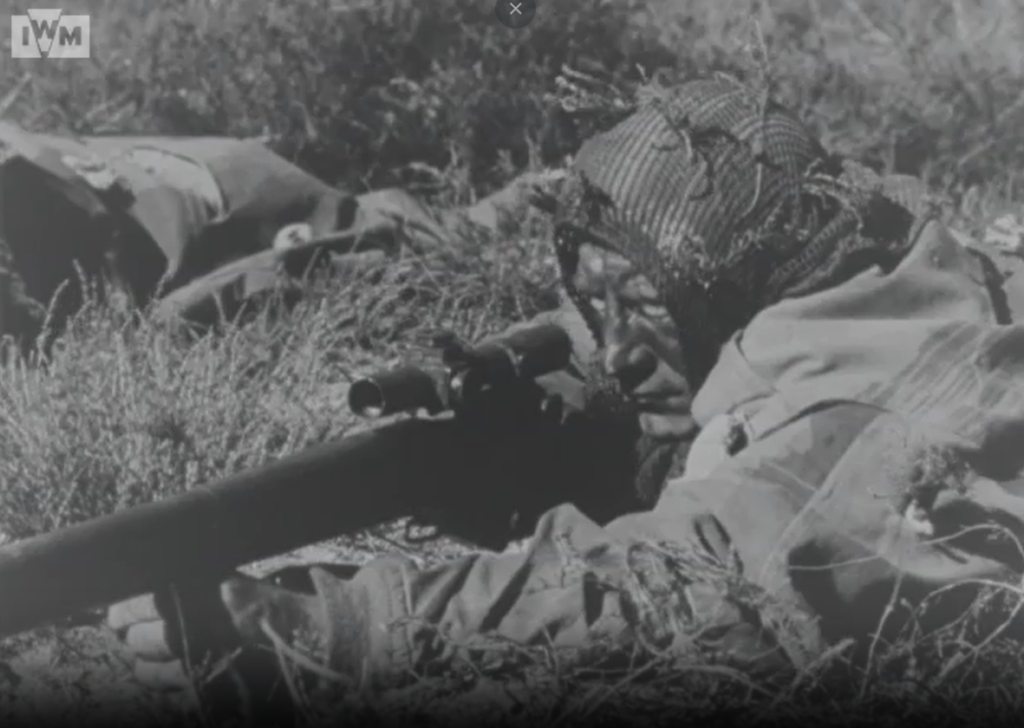 British sniper aiming while in prone position.